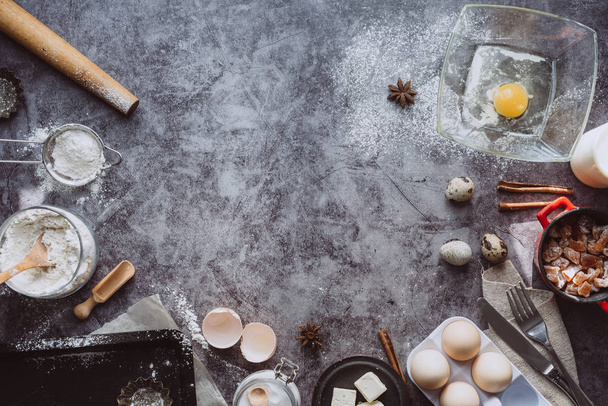 Healthy baking ingredients. Spoon with flour, dishes, eggs, butter salt and rolling pin on a grey background.Bakery background frame. Top view, copy space. - Φωτογραφία, εικόνα
