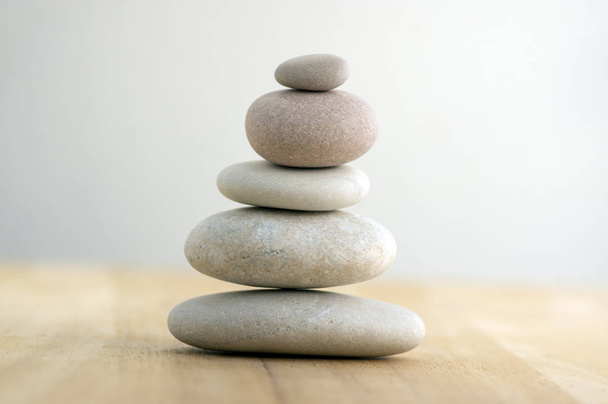 Stone cairn on striped grey white background, five stones tower, simple poise stones, simplicity harmony and balance, rock zen sculptures - 写真・画像