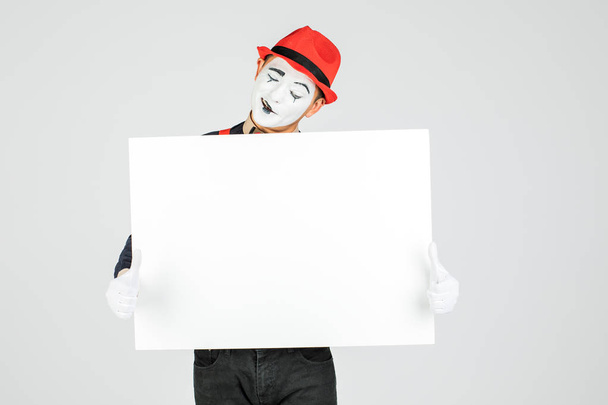 glücklicher MIME-Künstler mit einem leeren weißen Brett auf weißem Hintergrund - Foto, Bild