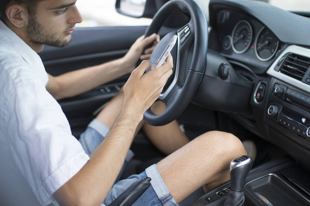 motorista no carro com o telefone celular
 - Foto, Imagem