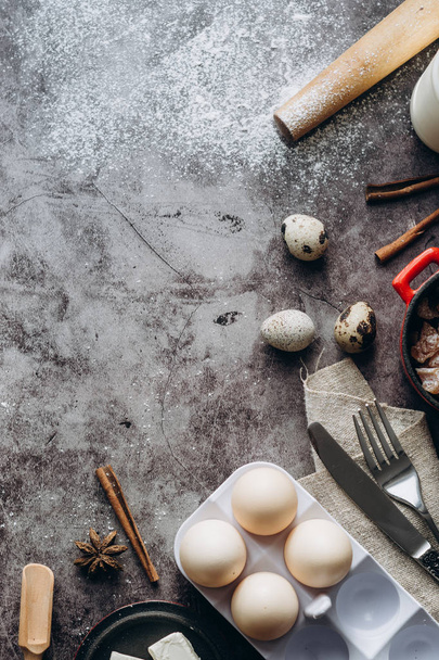 Healthy baking ingredients. Spoon with flour, dishes, eggs, butter salt and rolling pin on a grey background.Bakery background frame. Top view, copy space. - Fotoğraf, Görsel