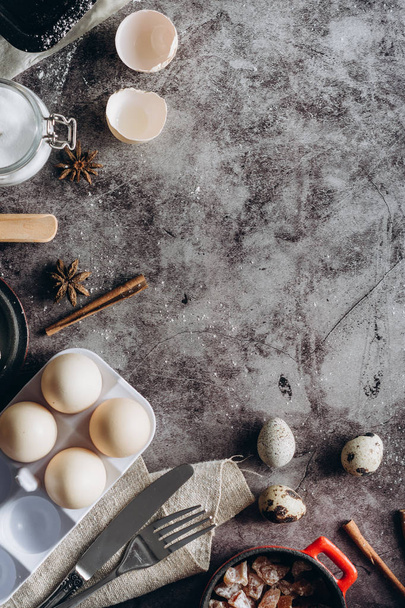 Healthy baking ingredients. Spoon with flour, dishes, eggs, butter salt and rolling pin on a grey background.Bakery background frame. Top view, copy space. - Foto, imagen
