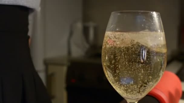 Pan up following champagne bubbles rising up to top of glass on dark background festive celebration holiday concept - Video