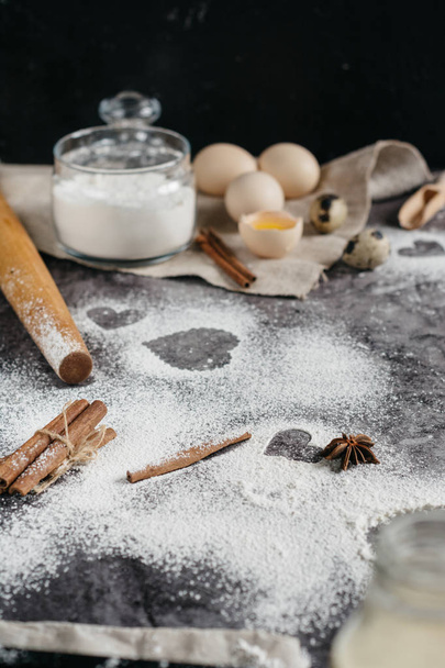 Healthy baking ingredients. Background with flour, rolling pin, eggs, and heart shape on kitchen gray kitchen table.  Top view for Valentines day cooking. Copy space. - Foto, imagen