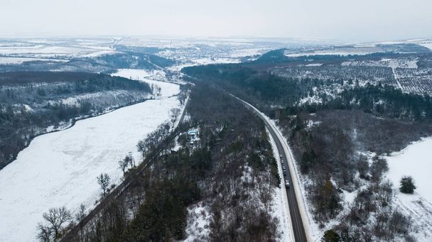 Luchtfoto drone weergave van de weg in idyllisch winterlandschap. - Foto, afbeelding