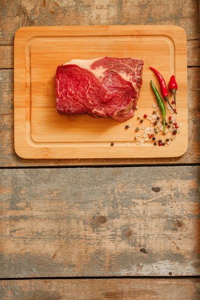 beef steak raw (Grilled meats with spices) - a piece of meat. Top view with copy space - Фото, изображение