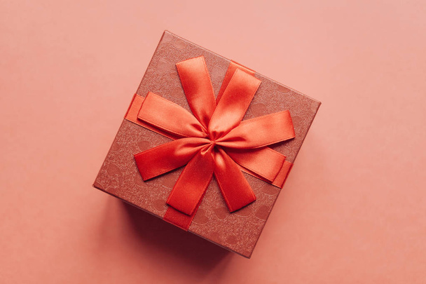 rote Schachtel mit Schleife und Geschenk auf rotem Hintergrund - Foto, Bild