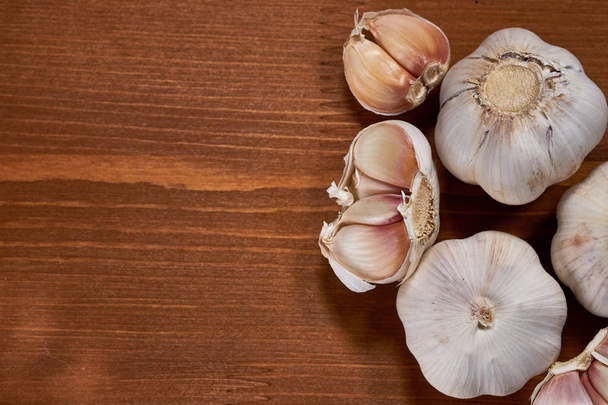 Garlic and garlic cloves on wooden background. - Fotografie, Obrázek