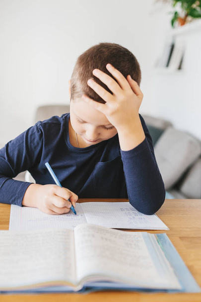Schoolboy doing his homework on desk at home. Homeschooling concept - Fotoğraf, Görsel