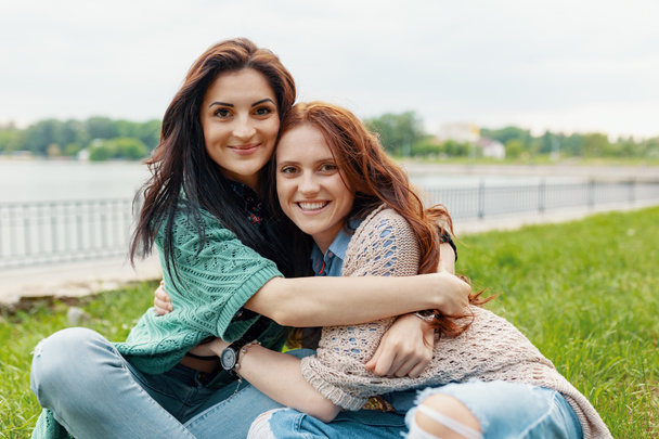 Close up lifestyle portrait of two pretty girlfriends smiling hugs and having fun. Sisters love. - Foto, imagen