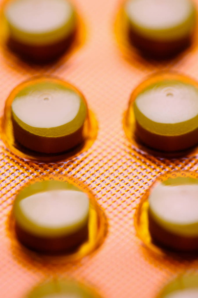 Enzym-Tabletten biologisch aktive Substanzen in orangefarbener Verpackung gefälschte Medikamente für Krebserkrankungen Konzept. Produktion und Verkauf von pharmazeutischen Präparaten für die verschreibungspflichtige Apotheke. - Foto, Bild