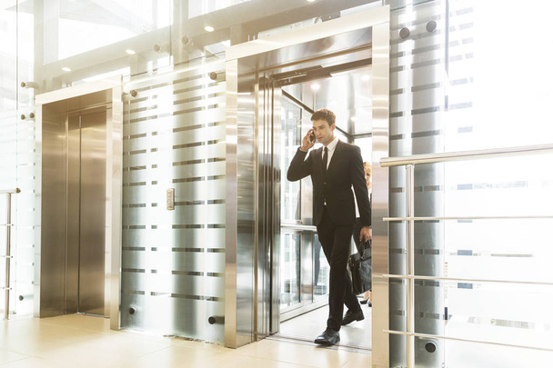 menestyvä ja nuori liikemies hississä business center ratsastaa töihin
 - Valokuva, kuva