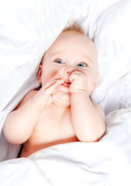 Cute little baby smiling over white blancket. - Φωτογραφία, εικόνα