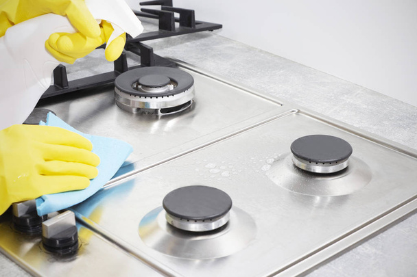 Limpeza de um fogão a gás com utensílios de cozinha, conceitos domésticos, ou higiene e limpeza - Foto, Imagem