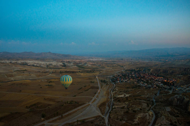 Cappadocia, Turkey : Hot Air Balloons are flying during sunrise in Cappadocia Region of Turkey. Balloon against the blue sky in flight, colorful fun entertaining form of transport, flight in the air of the balloon, the concept of dream and happiness - Fotoğraf, Görsel