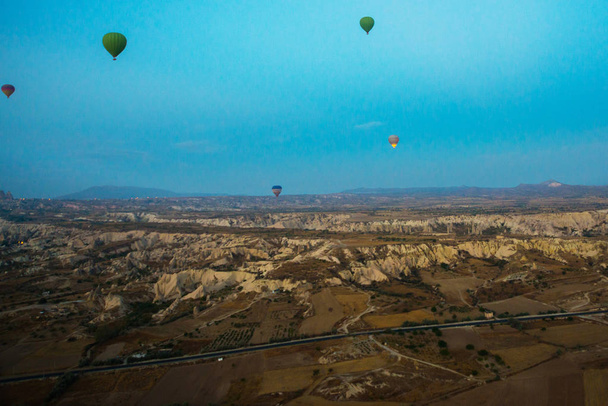 Cappadocia, Turkey : Hot Air Balloons are flying during sunrise in Cappadocia Region of Turkey. Balloon against the blue sky in flight, colorful fun entertaining form of transport, flight in the air of the balloon, the concept of dream and happiness - Fotografie, Obrázek