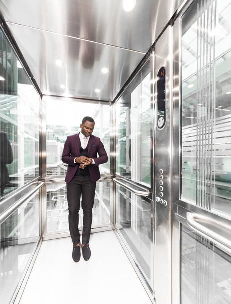 успешный и молодой бизнесмен в лифте бизнес-центра едет на работу
 - Фото, изображение