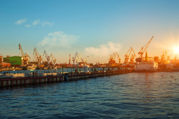 美しい夕日、目に見えるポート クレーン、サンクトペテルブルグ、ロシア、ネヴァ川のポートの船。ワシリエフ スキー島. - 写真・画像