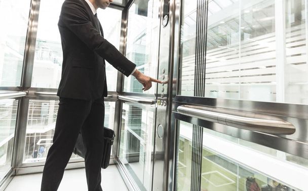 Man pressing elevator button. finger presses elevator button. businessman in lift - Zdjęcie, obraz