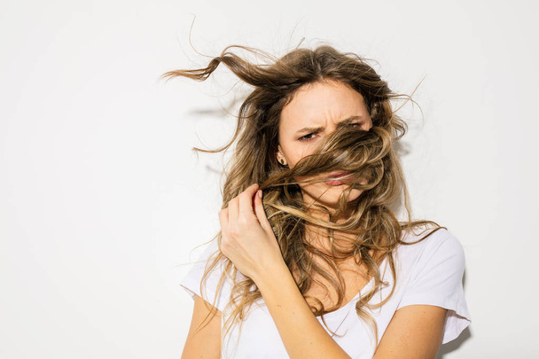 portrait of a young and expressive woman playing with her blowing hair - Fotoğraf, Görsel