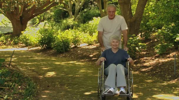 Man walking with a woman in a wheelchair - Filmmaterial, Video