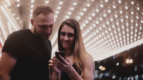 Szczęśliwy uśmiechający się turystyczny nowożeńcy para rozejrzeć się w niesamowite theater Chicago za pomocą smartfona, odchodzisz razem. - Materiał filmowy, wideo