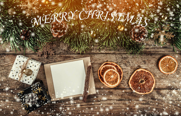 Δημιουργική σελιδοποίηση Κάσια από χριστουγεννιάτικο δέντρο κλαδιά, Σημείωση κάρτα χαρτί, κουκουνάρια, δώρα, χρυσή διακόσμηση σε ξύλινο υπόβαθρο. Χριστούγεννα και το νέο έτος θέμα, νιφάδες χιονιού, φως. Επίπεδη lay, κορυφαία προβολή - Φωτογραφία, εικόνα