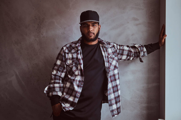 African-American bearded man wearing a checkered shirt and cap - 写真・画像