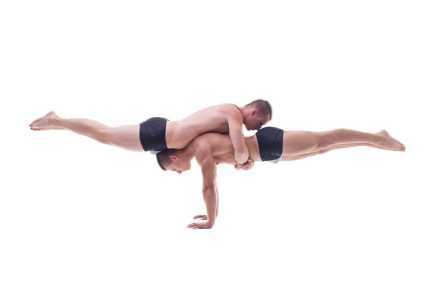 Muscled acrobats keep balance - Zdjęcie, obraz