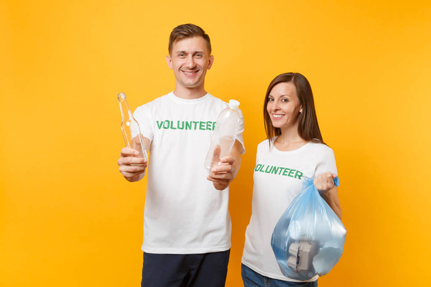 Коллеги пара в футболке волонтер мешок для мусора изолированы на желтом фоне. Помощь поможет благотворительности благодати командной работы. Проблема загрязнения окружающей среды. Остановить охрану окружающей среды
 - Фото, изображение