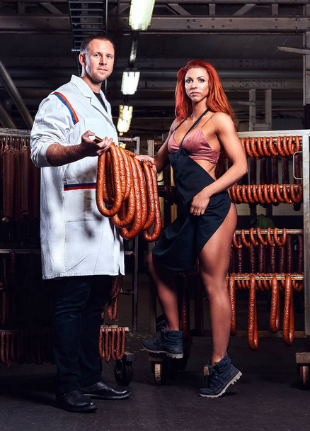 Butcher and his sexy girl assistant in the storage room. - Photo, Image