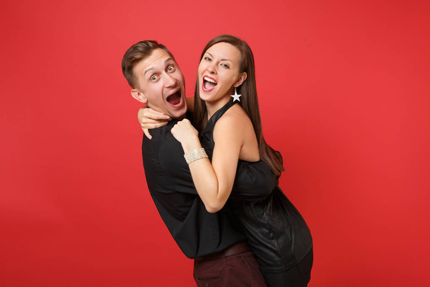 Fashionable young couple in black clothes shirt dress celebrating birthday holiday party isolated on bright red background. St. Valentine International Women Day Happy New Year 2019 concept. Mock up - Foto, imagen