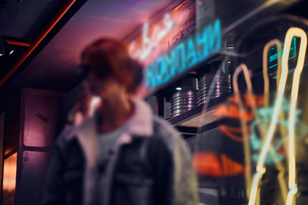 Blurred silhouette of a stylish girl standing in the night on the street. - Φωτογραφία, εικόνα
