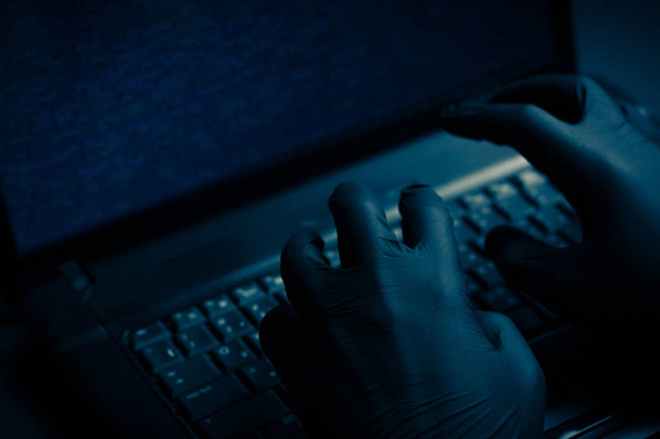 Internetes hacker tolvaj koncepció. Hacker használ laptop, számítástechnikai berendezések támadni. Sötét és félelmetes világítás. Egy csomó jelképek a számítógép képernyőjén. Szelektív összpontosít. - Fotó, kép