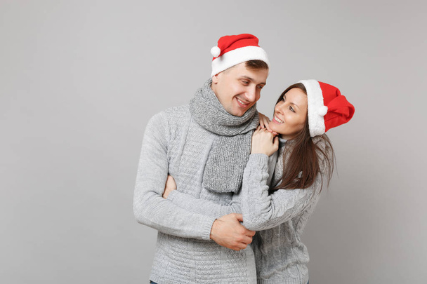 Neşeli eğlenceli çift kız adam Santa Noel şapka gri kazak eşarp gri duvar arka planda, stüdyo portre izole kırmızı. Mutlu yeni yıl 2019 kutlama tatil parti kavramı. Kopyalama alanı alay - Fotoğraf, Görsel