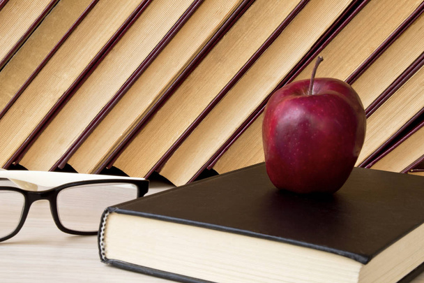 eski kitaplar, gözlük ve ahşap raf kırmızı elmalar. - Fotoğraf, Görsel