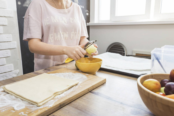 happy woman is preparing a pie in the kitchen at home. concept of happy family and home coziness - 写真・画像
