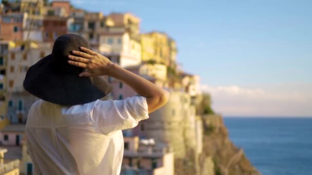 girl in a hat looks at the city of Manarola Italy - Footage, Video