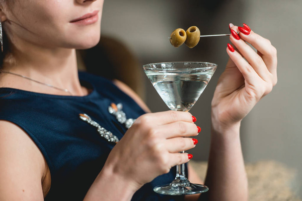 Cocktail Martini seco em mãos de mulher com manicura vermelha. Luxery hotel lobby bar
. - Foto, Imagem