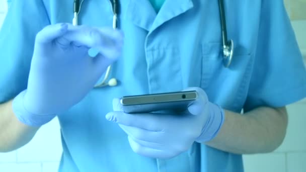 Doctor in de blauwe handschoenen en blauw wordt uitgevoerd op een mobiele telefoon - Video