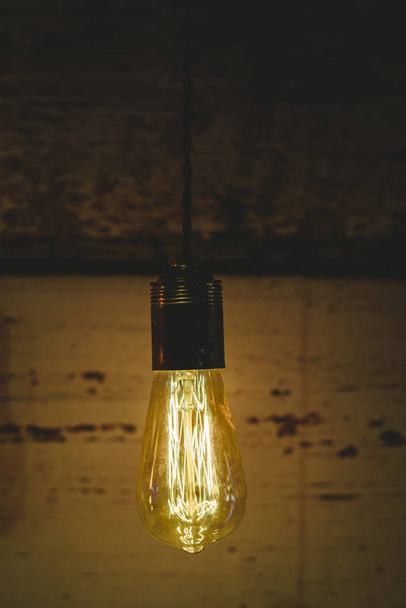 Ретро декоративные лампочки светятся теплым цветом на темном деревянном фоне
. - Фото, изображение