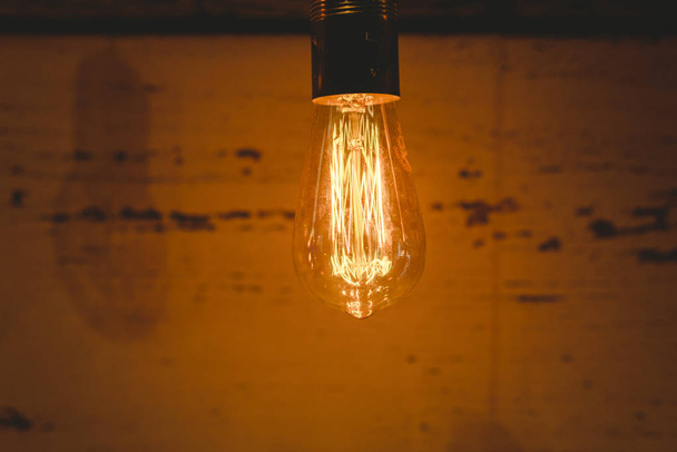 Retro decorative light bulbs lighted of warm color on dark wooden background. - Foto, afbeelding
