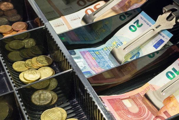 Vue grand angle du tiroir caisse plein de pièces et de billets en euros
 - Photo, image