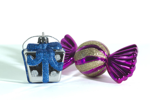 Cerrar una mini caja de regalo de plata simulada y brillo azul y oro una forma de caramelo para decoraciones de Año Nuevo y fiestas de Navidad, aislado sobre fondo blanco
. - Foto, Imagen