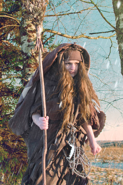 portrait d'une jeune sorcière fougueuse aux cheveux échevelés par le vent d'hiver et un balai à la main
 - Photo, image