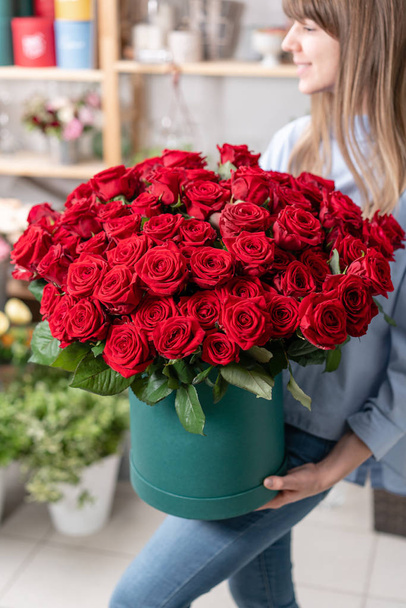 Big luxury jasny bukiet w rękach cute girl. Stu ogród czerwonych róż. Kolor namiętnie szkarłat, jesienny nastrój. bukiet w polu kapelusz - Zdjęcie, obraz