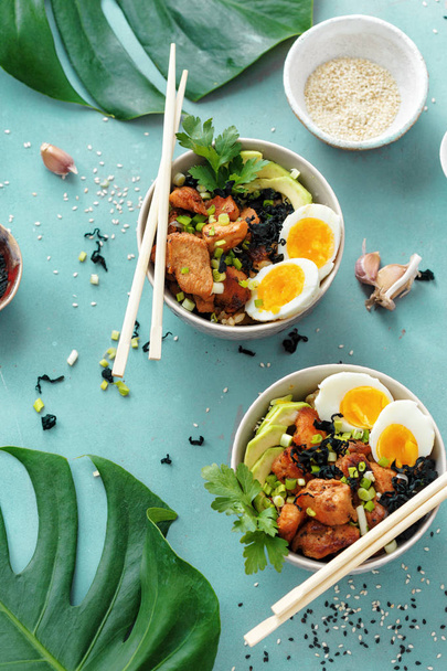 Top view poke bowls of fried rice, chicken fillet and eggs top view. Asian food concept - 写真・画像