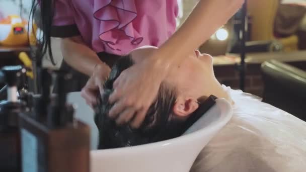 Hairdresser washes womans hair in the beauty studio. - Séquence, vidéo