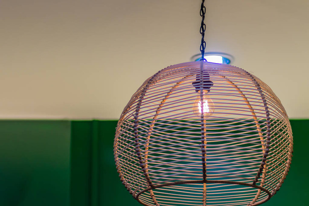 Classic interior decoration style bamboo weave pattern lamp. Vintage lamp with bamboo netting with curls hanging on ceiling. - Fotografie, Obrázek