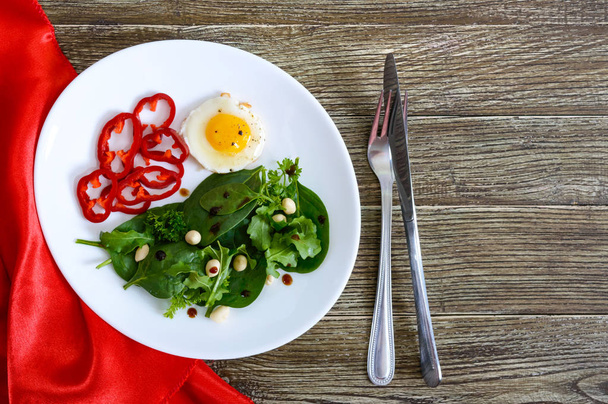 leichtes Frühstück - Wachtelei, grüner Salat, Paprika auf einem Holztisch. Ansicht von oben. Gesunde Ernährung. Richtige Ernährung. - Foto, Bild